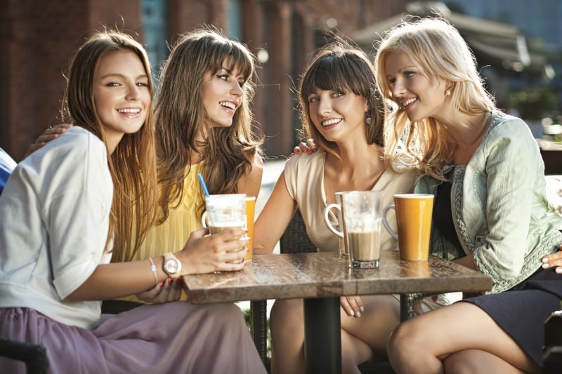 A group of woman sitting together at a coffee shop outside