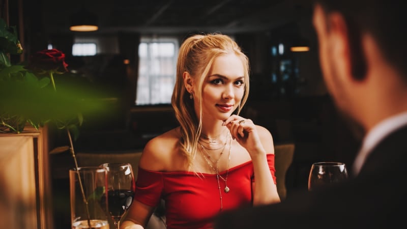 Attractive woman flirting with attractive man in suit at dinner