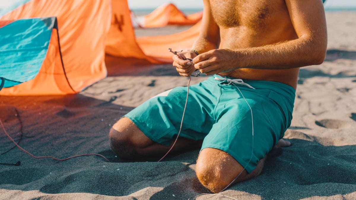 Best Board Shorts for Men Man on Beach In Board Shorts Getting Ready for Kite Surfing