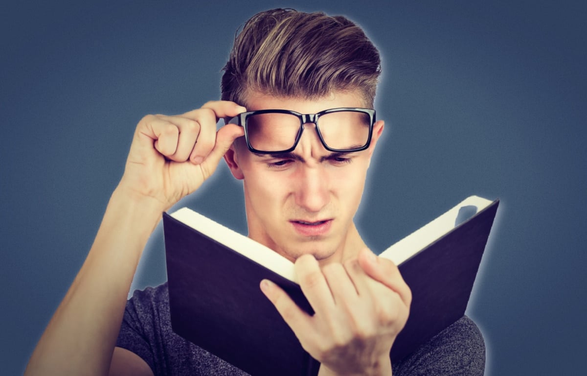 Best Dating Books Young Man in Glasses Reading a Navy Book and Shocked at What Hes Reading