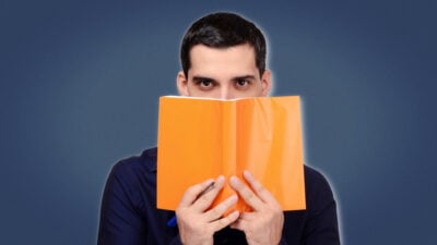 2022/12/Books-on-Persuasion-Man-Hiding-Behind-Orange-Book.jpg