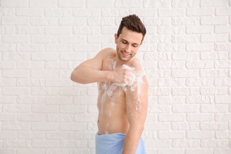 handsome man taking shower white