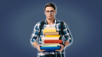 2021/06/Life-Lessons-for-Men_-Student-With-Glasses-and-Backpack-Holding-a-bunch-of-books.jpg
