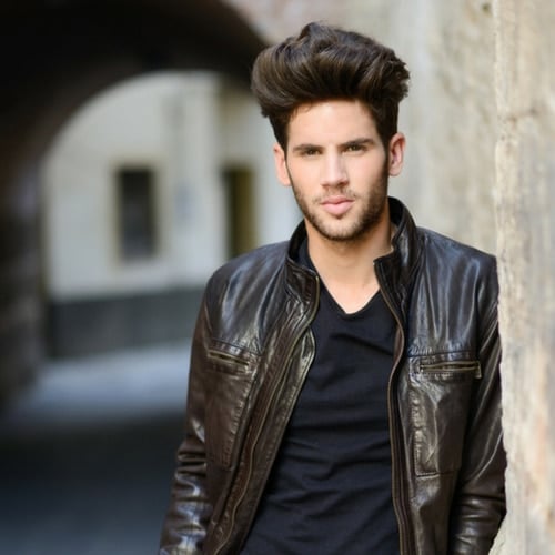 man with oval face and a large quiff wearing a leather jacket