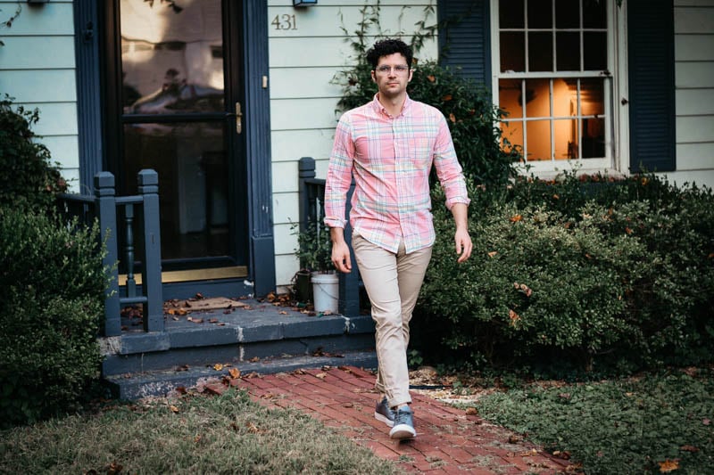 model walking out of house with pink madras shirt and performance chinos from J.Crew