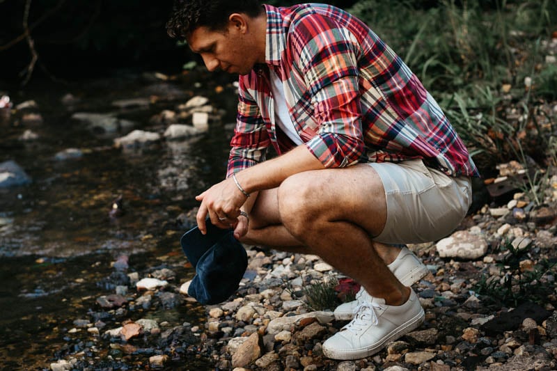 model wearing j crew outfit crouching by river