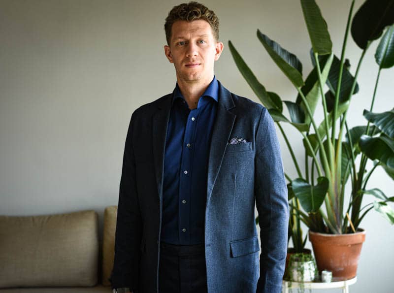 model wearing navy suit and dark blue shirt