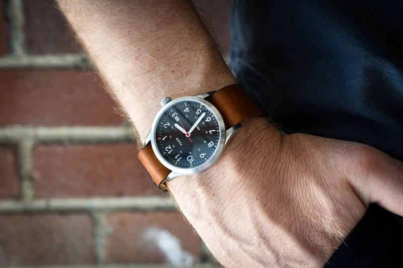 model wearing vaer c5 black heritage field watch with leather single pass horween strap