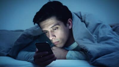 2021/03/Oneitis_-Man-in-Bed-with-Phone-Sad-Waiting-for-a-Text-Message-From-His-Crush.jpg