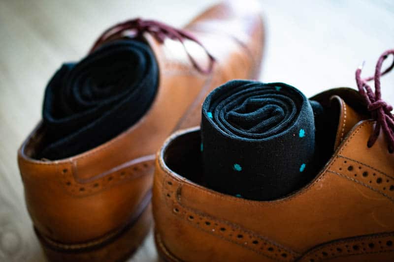 teal and navy polka dot sock rolled into leather oxford shoe